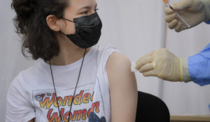 A girl gets a Pfizer COVID-19 vaccine in Bucharest, Romania, Wednesday, June 2, 2021. (AP Photo/Andreea Alexandru)