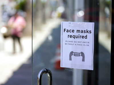 Virus Outbreak-US A sign advises shoppers to wear masks outside of a store Monday, July 19, 2021, in the Fairfax district of Los Angeles. Los Angeles County has reinstated an indoor mask mandate due to rising COVID-19 cases, largely caused by the highly contagious delta variant. (AP Photo/Marcio Jose Sanchez)