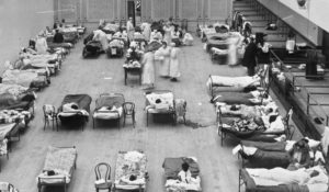 In this 1918 photo made available by the Library of Congress, volunteer nurses from the American Red Cross tend to influenza patients in the Oakland Municipal Auditorium, used as a temporary hospital. (Edward A. "Doc" Rogers/Library of Congress via AP)