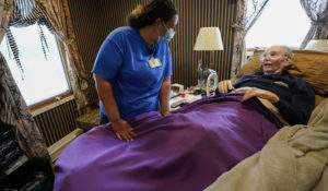 Nurse practitioner Amber Vitale, left, talks to Arthur Katz before inoculating him against the coronavirus at his home in Bellmore, N.Y., Thursday, May 20, 2021. (AP Photo/Mary Altaffer)