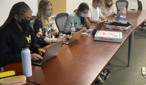 Students at the University of Miami share pizza while researching their topic for the Poynter College Media Project. (Photo by Barbara Allen)