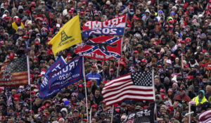 People wave flags as President Donald Trump speaks Wednesday, Jan. 6, 2021, in Washington. (AP Photo/Evan Vucci)
