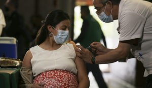 A pregnant woman gets a Pfizer vaccine shot for COVID-19 at a library converted into a vaccination center in Mexico City, Thursday, May 13, 2021. (AP Photo/Fernando Llano)