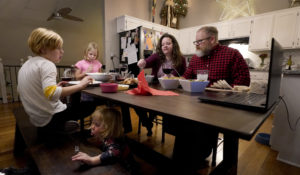 Jessica and John Franz have Thanksgiving dinner with their daughters Amelia, age 11, left, Molly, age 8, back and Quinn, age 2, front, Thursday, Nov. 26, 2020, in Olathe, Kan. The family had a quiet, scaled-back Thanksgiving with just their household attending in person due to concerns about the virus. (AP Photo/Charlie Riedel)