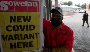 A petrol attendant stands next to a newspaper headline in Pretoria, South Africa on Saturday. (AP Photo/Denis Farrell)
