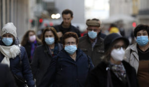 People wearing face masks to curb the spread of COVID-19 walk in downtown Lisbon, Monday, Nov. 29, 2021. Portuguese health authorities on Monday identified 13 cases of omicron, the new coronavirus variant spreading fast globally, among members of the Lisbon-based Belenenses SAD soccer club, and were investigating possible local transmission of the virus outside of southern Africa. (AP Photo/Ana Brigida)