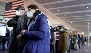 Travelers wait in a line while entering a security checkpoint at Logan International Airport, in Boston, Wednesday, Nov. 24, 2021, the day before Thanksgiving. (AP Photo/Steven Senne)