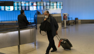 A traveler adjusts his face mask as he walks through the arrivals area at the Los Angeles International Airport in Los Angeles, Nov. 30, 2021. (AP Photo/Jae C. Hong, File)