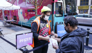 A health care worker, left, checks in a man at a NYC mobile vaccine clinic in the Manhattan borough of New York, Monday, Dec. 6, 2021. (AP Photo/Mary Altaffer, File)