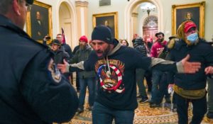 Trump supporters gesture to U.S. Capitol Police in the hallway outside of the Senate chamber at the Capitol in Washington on Jan. 6, 2021. (AP Photo/Manuel Balce Ceneta)