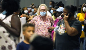 Applicants wait in line with their paperwork for utility assistance at a rental assistance fair for Jackson residents at the Mississippi Trademart in the state Fairgrounds, Saturday, July 24, 2021, in Jackson, Miss. (AP Photo/Rogelio V. Solis)