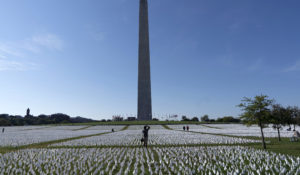 Visitors walks through artist Suzanne Brennan Firstenberg's "In America: Remember," a temporary art installation made up of white flags to commemorate Americans who have died of COVID-19, on the National Mall, in Washington, Saturday, Oct. 2, 2021. (AP Photo/Jose Luis Magana)
