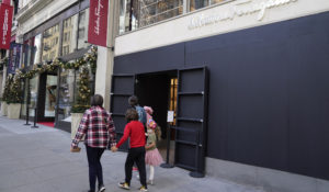 People walk past a boarded storefront window of a Salvatore Ferragamo store following recent robberies near Union Square in San Francisco, on Dec. 2, 2021. (AP Photo/Eric Risberg, File)