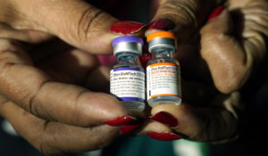 Jackson-Hinds Comprehensive Health Center nurse Maggie Bass holds a vial of the Pfizer COVID-19 vaccine for children ages 5 - 11 on the right while in her left hand is a vial of the vaccine for adults, at the vaccination station next to Jackson State University in Jackson, Miss., Tuesday, Feb. 8, 2022. (AP Photo/Rogelio V. Solis)