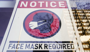 A sign requiring masks as a precaution against the spread of the coronavirus is posted on a store front in Philadelphia, on Feb. 16, 2022. The Biden administration will significantly loosen federal mask-wearing guidelines to protect against COVID-19 transmission on Friday, according to two people familiar with the matter. (AP Photo/Matt Rourke, File)