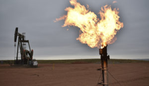 A flare to burn methane from oil production is seen on a well pad near Watford City, North Dakota, Aug. 26, 2021. (AP Photo/Matthew Brown)