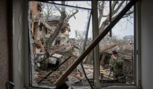 Andrey Goncharuk, 68, a member of territorial defense, wipes his face in the backyard of a house that was damaged by a Russian airstrike, according to locals, in Gorenka, outside the capital Kyiv, Ukraine, on Wednesday. (AP Photo/Vadim Ghirda)