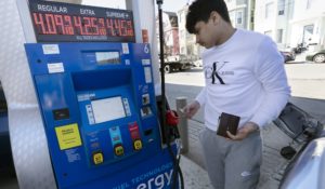 Jason Ventura prepares to pump gas into his vehicle, Friday, March 4, 2022, in Boston. (AP Photo/Michael Dwyer)