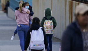 Children and their caregivers arrive for school in New York, Monday, March 7, 2022.  (AP Photo/Seth Wenig)