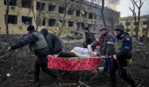 Ukrainian emergency employees and volunteers carry an injured pregnant woman from the damaged by shelling maternity hospital in Mariupol, Ukraine on March 9. (AP Photo/Evgeniy Maloletka)