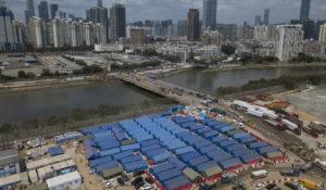 An aerial view of a construction site for COVID-19 isolation facilities and a temporary bridge linked between China’s Shenzhen and Hong Kong’s Lok Ma Chau, in Hong Kong, Friday, March 11, 2022. (AP Photo/Kin Cheung)