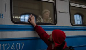 Displaced Ukrainians on a Poland-bound train bid farewell in Lviv, western Ukraine, on Tuesday. (AP Photo/Bernat Armangue)