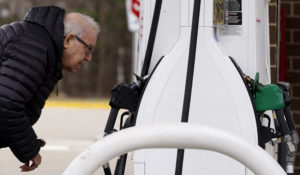 A man checks gas prices at a gas station in Buffalo Grove, Illinois, this spring. (AP Photo/Nam Y. Huh)