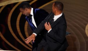 Will Smith, right, hits presenter Chris Rock on stage while presenting the award for best documentary feature at the Oscars on Sunday. (AP Photo/Chris Pizzello)