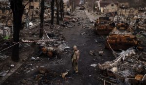 A Ukrainian serviceman stands amid destroyed Russian tanks in Bucha, on the outskirts of Kyiv, Ukraine on Wednesday. (AP Photo/Felipe Dana)