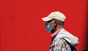A pedestrian wearing a protective mask as a precaution against the spread of the coronavirus walks in Philadelphia, Friday, April 22, 2022. (AP Photo/Matt Rourke)