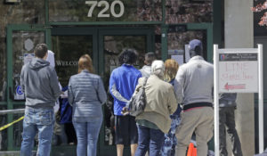 In this April 13, 2020, file photo, people line up outside the Utah Department of workforce Services, in Salt Lake City. (AP Photo/Rick Bowmer, File)