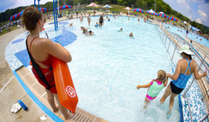 Lifeguard Maggie Storti, left, keeps an eye on visitors to the North Boundary Park swimming pool and waterpark, as temperatures hit over 90 degrees Thursday, July 9, 2020, in Cranberry Township, Pa. (AP Photo/Keith Srakocic)