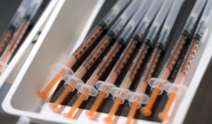 Vials of the Moderna COVID-19 vaccines being administered for local residents sit in a tray at a mass vaccination center operated by Japanese Self-Defense Force Monday, Jan. 31, 2022, in Tokyo. (AP Photo/Eugene Hoshiko, Pool)