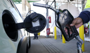 A worker fills up the tank of a new car at the Boston Autoport terminal along the Charlestown waterfront, Tuesday, May 24, 2022, in Boston. (AP Photo/Charles Krupa)