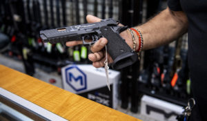 Salesman John Licata shows a handgun that's available for purchase at SP firearms on Thursday, June 23, 2022, in Hempstead, New York. (AP Photo/Brittainy Newman)