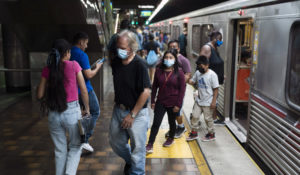 Masked and unmasked commuters are seen at a Metro station in Los Angeles, Wednesday, July 13, 2022. (AP Photo/Jae C. Hong)