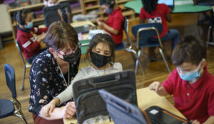 Kindergarten teacher Karen Drolet, left, works with a student at Raices Dual Language Academy, a public school in Central Falls, Rhode Island, in February. (AP Photo/David Goldman)