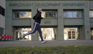 A runner passes the office of the California Employment Development Department in Sacramento, Calif., on Dec. 18, 2020. About $1.1 billion in unused unemployment benefits returned to California on Tuesday, June 21, 2022, money state officials said was most likely attempted fraud during the pandemic.  (AP Photo/Rich Pedroncelli, File)