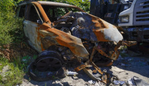 A burned out car sits on the side of the road in Philadelphia, Thursday, July 14, 2022. (AP Photo/Matt Rourke)