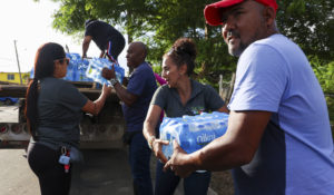 A man collects donated water bottles for drinking after Hurricane Fiona damaged water supplies in Toa Baja, Puerto Rico, Tuesday, Sept. 20, 2022. (AP Photo/Stephanie Rojas)