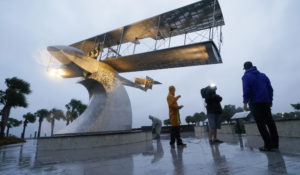 A television news crew prepares to deliver a report on the effects of Hurricane Ian near a statue of a flying boat Sept. 28 in St. Petersburg, Florida. (AP Photo/Steve Helber)