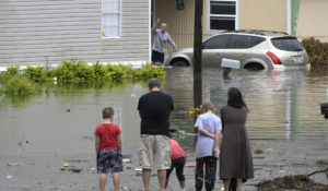 Residents check on one another in a flooded neighborhood in the aftermath of Hurricane Ian on Thursday in Orlando, Florida. (AP Photo/Phelan M. Ebenhack)