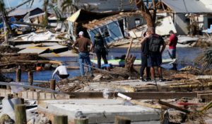 People stand on the destroyed bridge to Pine Island as they view the damage in the aftermath of Hurricane Ian in Matlacha, Fla. on Sunday. (AP Photo/Gerald Herbert)