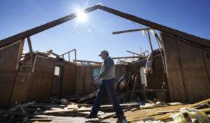 Danny Palmer, a deacon at Trinity Baptist Church, walks across the destroyed church's sanctuary Nov. 5 while looking for items to salvage after a tornado hit Idabel, Okla. (AP Photo/LM Otero)