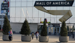 FILE - Shoppers, visitors and employees exit the Mall of America on March 17, 2020 as the mall in Bloomington, Minn. (AP Photo/Jim Mone, File)