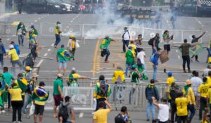 Supporters of Brazil's former President Jair Bolsonaro clash with police as they storm the Planalto Palace in Brasilia, Brazil on Sunday. (AP Photo/Eraldo Peres)