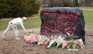 A student leaves flowers at The Rock on the grounds of Michigan State University, in East Lansing, Mich. on Tuesday — a day after a gunman killed several people and wounded others. Police said early Tuesday that the shooter eventually killed himself. (AP Photo/Paul Sancya)