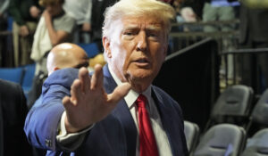Former President Donald J. Trump waves as he arrives for the NCAA Wrestling Championships, Saturday, March 18, 2023, in Tulsa, Okla. (AP Photo/Sue Ogrocki)