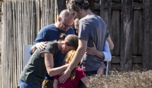 A group prays with a child outside the reunification center at the Woodmont Baptist church after a school shooting on Monday in Nashville. (AP Photo/John Bazemore)