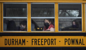 Students from Regional School Unit 5 wear face coverings as they head home on a school bus, Wednesday, Jan. 5, 2022, in Freeport, Maine. (AP Photo/Robert F. Bukaty)